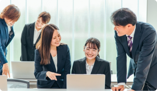 ノートパソコンを囲んで相談するチーム